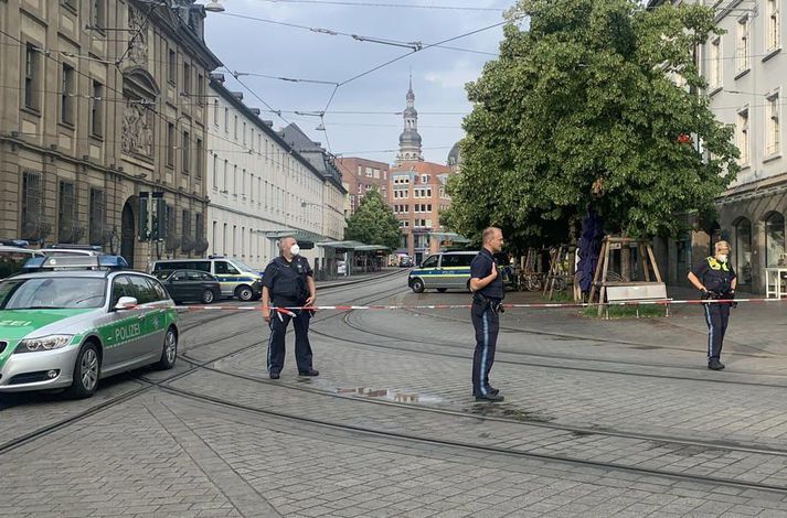 Lögreglumenn standa vörð við borða sem var strengdur í kringum vettvanginn í miðborg Würzburg í dag.