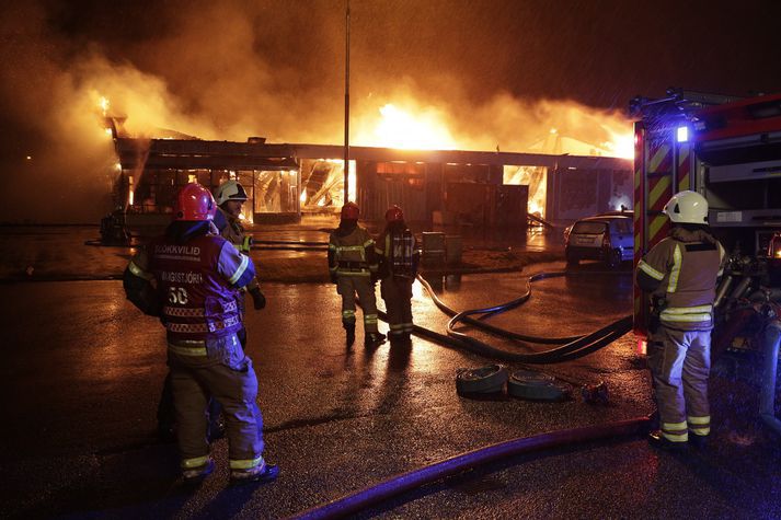 lökkviliðsmenn áttu í fullu fangi með að ráða niðurlögum eldsins enda aðstæður erfiðar, hvasst og rigning.