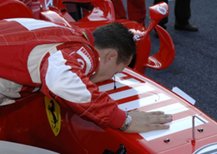 Michael Schumacher kyssir Ferrari-bíl sinn eftir sinn síðasta kappakstur á ferlinum á síðasta ári.