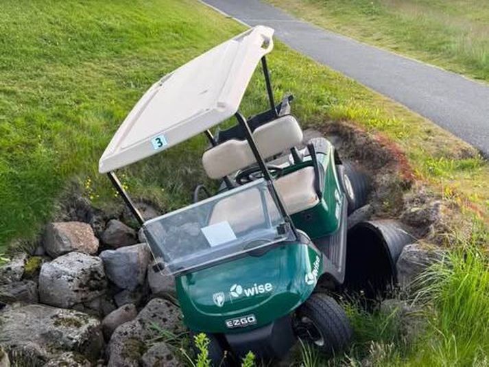 Ungur kylfingur ók þessum golfbíl út af stígnum, sem betur fer slasaðist enginn alverlega.