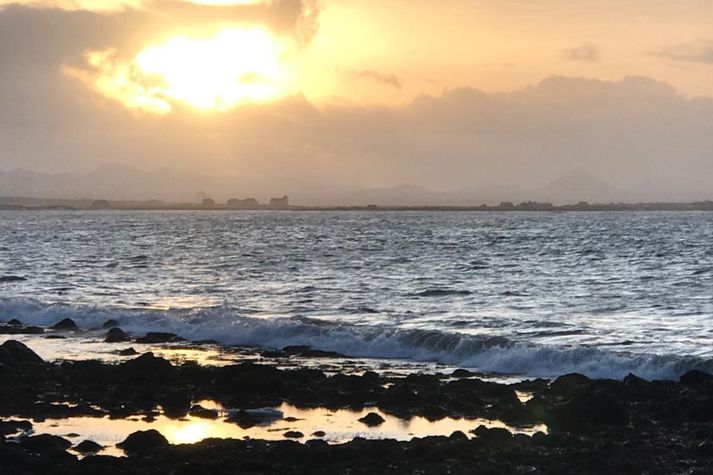 Skíma vetrarsólar yfir Bessastöðum og Reykjanesfjallgarði í dag, séð frá Ægissíðu í vesturbæ Reykjavíkur.