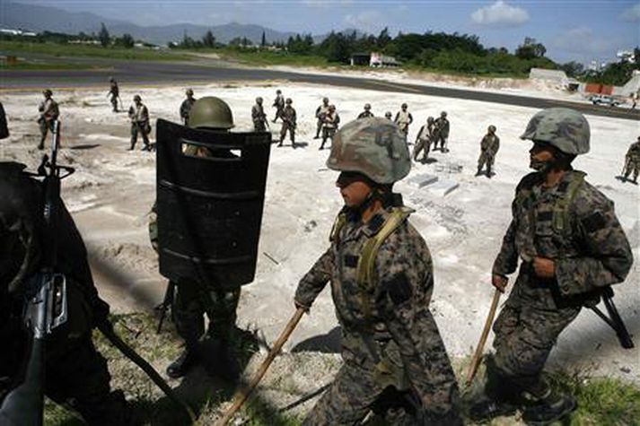 Hermenn, gráir fyrir járnum, á flugvellinum í Tegucigalpa í gær.