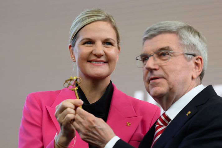 Kirsty Coventry, nýr forseti Alþjóða Ólympíunefndarinnar, tekur hér við lyklinum af fráfarandi forseta, Thomas Bach í dag í Lausanne í Sviss.