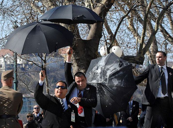 Öryggisverðir notuðu regnhlífar til að verjast eggjakasti.