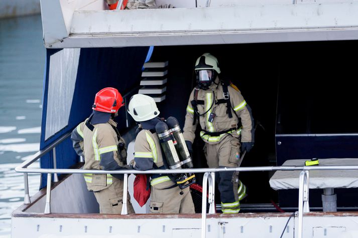 Slökkviliðsmenn um við slökkvistörf í snekkjunni í morgun.