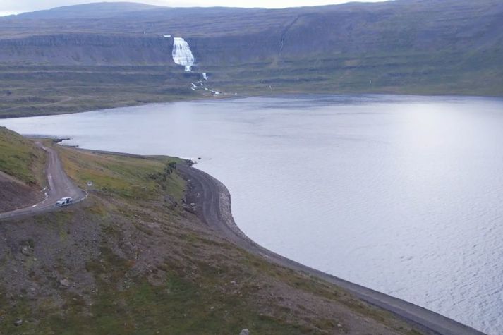 Frá Dynjandisvogi. Gamli vegurinn er í hlíðinni en sá nýi með slitlaginu við fjöruborð.