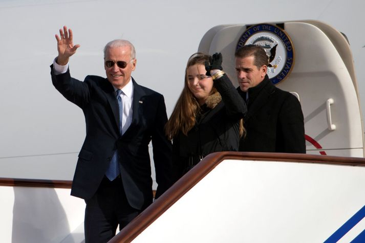 Biden við komuna til Beijing, með honum í för er sonur hans Hunter, og barnabarnið Finnegan.