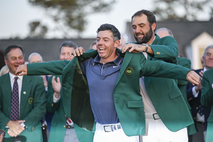 Scottie Scheffler klæðir Rory McIlroy í græna jakkann fyrir ári síðan en þeir hafa unnið tvö síðustu Mastersmót í golfi.
