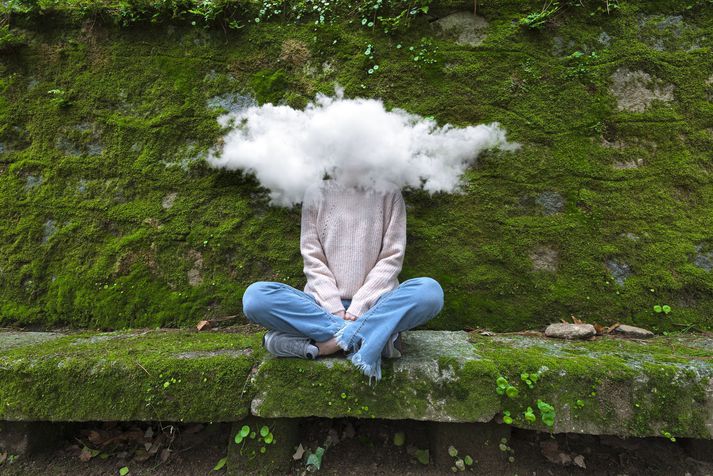 Shyness Young and timid woman with head in the cloud sitting on bench
