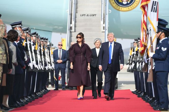 Melania og Donald Trump lentu í Suður-Kóreu nú í morgun. Utanríkisráðherra landsins, Kang Kyung-wha, sést hjá á milli þeirra hjóna.