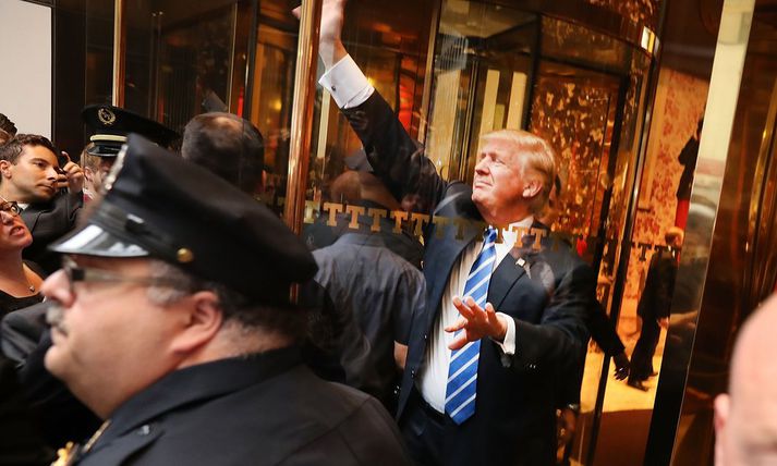 Donald Trump heilsar stuðningsmönnum sínum í New York í dag.