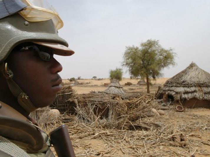 Hermaður frá Afríkubandalaginu horfir yfir þorp í Darfur sem lagt hefur verið í rúst.