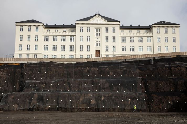 Maðurinn á myndinni gengur þar sem bílakjallari verður þegar húsið verður tilbúið.