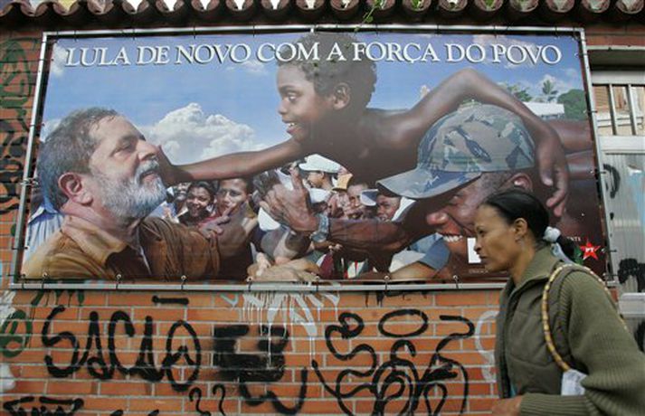 Kona gengur framhjá kosningaplakati Lula da Silva í Brasilíu
