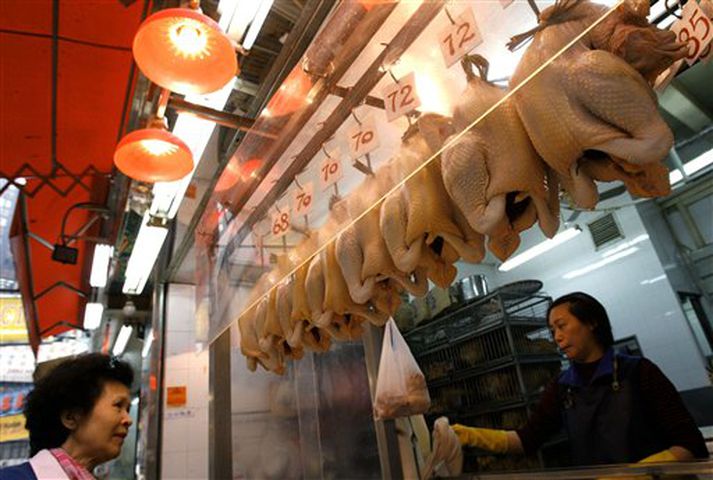 Kona kaupir fuglakjöt í Hong Kong.