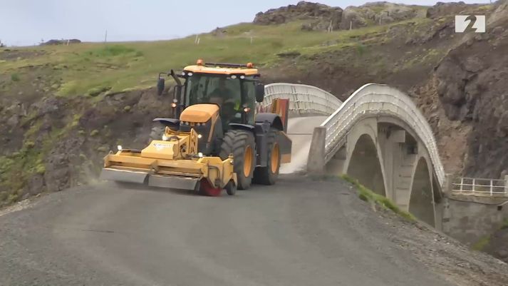 Gamla Hvítárbrúin er núna komin með malbikstengingu. Sópari frá Borgarverki sópar lausamöl af nýja slitlaginu.