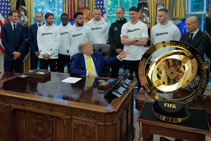 Donald Trump Bandaríkjaforseti sat við borðið sitt og spurði leikmenn Juventus spurninga. Fremst má sjá bikarinn sem keppt er um í heimsmeistarakeppni félagsliða.