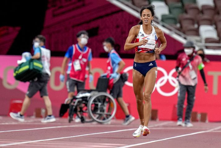 Katarina Johnson-Thompson haltrar hér í mark en á bak við hana má sjá hjólastólinn sem hún afþakkaði.