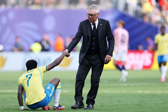 Carlo Ancelotti hjálpar Vinicius Junior á fætur eftir tapið sára á móti Noregi í sextán liða úrslitum heimsmeistaramótsins.