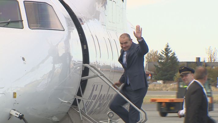 Forseti Íslands, Guðni Th. Jóhannesson, veifar í kveðjuskyni um leið og hann gengur um borð í flugvél Air Iceland á Reykjavíkurflugvelli í dag í fylgd flugstjórans, Ólafs Georgssonar.