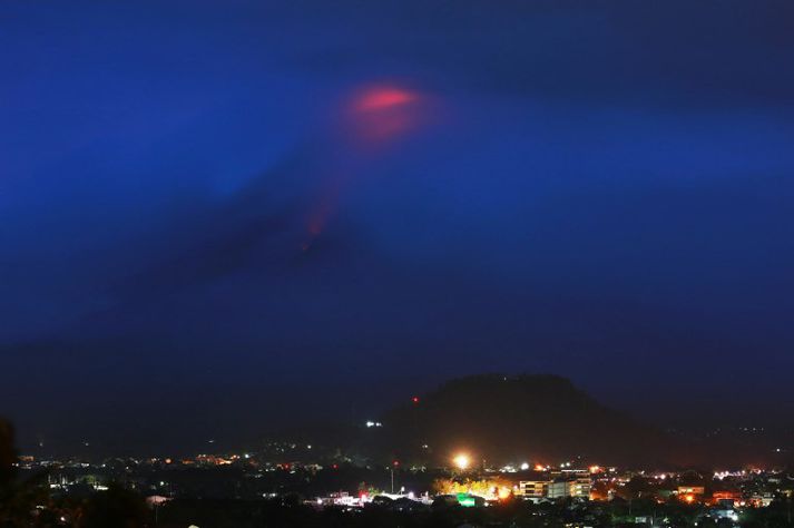 Bjarmi af hrauni sem vellur upp úr tindi Mayon sást í gær.