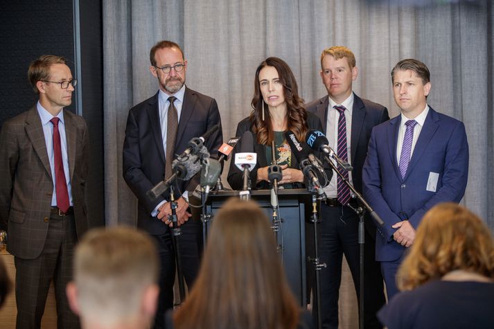 Jacinda Ardern, forsætisráðherra Nýja-Sjálands, er hér fyrir miðju. Með henni á myndinni eru landlæknir Nýja-Sjálands og ráðherrar í ríkisstórn hennar.