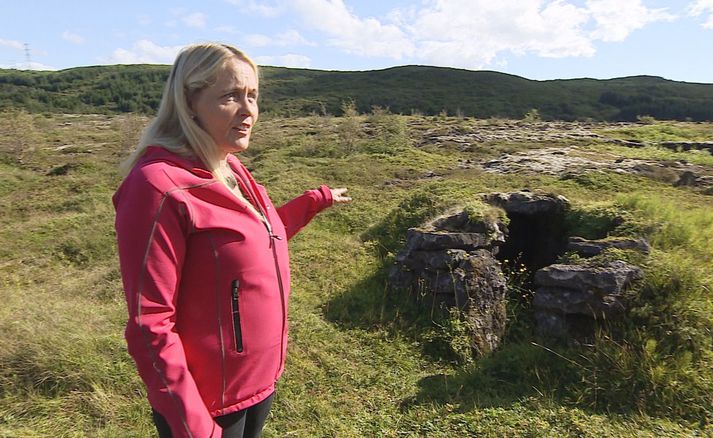 Ragnheiður Traustadóttir fornleifafræðingur við hlaðinn munna Þorsteinshellis.