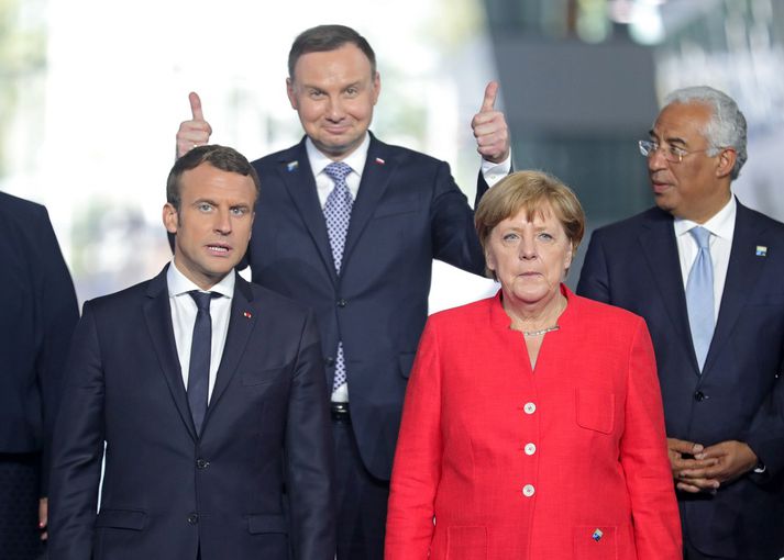 Emmanuel Macron Frakklandsforseti og Angela Merkel Þýskalandskanslari. Andrzej Duda er þarna eldhress fyrir aftan.