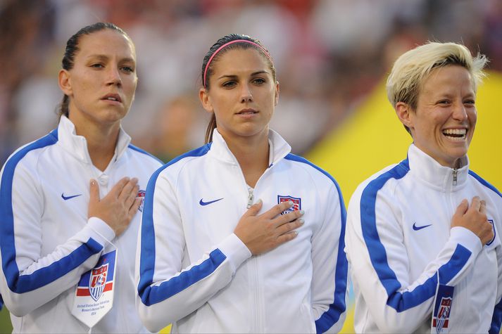 Megan Rapinoe og Alex Morgan hlusta á bandaríska þjóðsönginn.