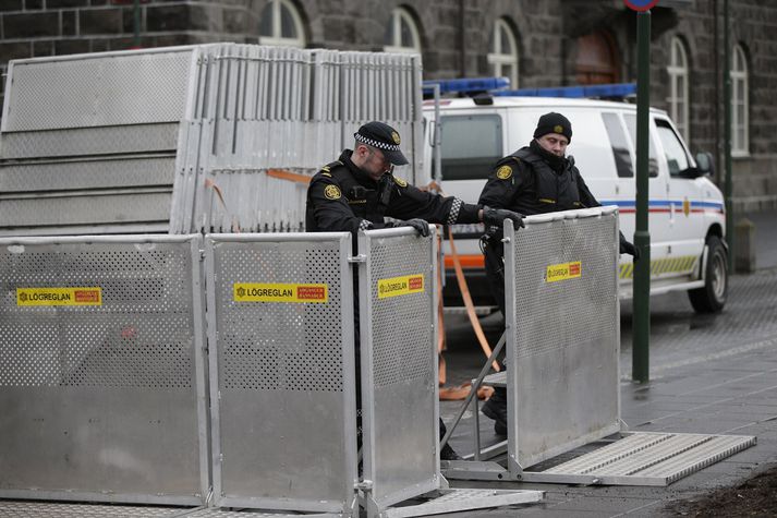 Lögreglumenn setja upp girðingar við þinghúsið vegna mótmælanna í dag.