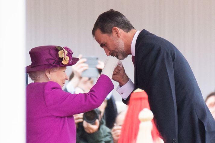 Spánarkonungur kyssir hér hönd Bretadrottningar við heimsóknina í dag.