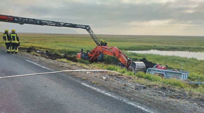 Unnið var við það í morgun í að ná gröfunni upp.
