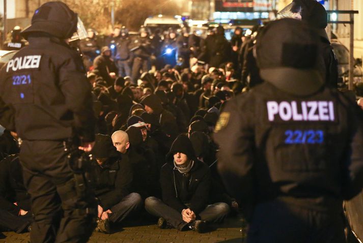 Lögreglumenn fylgjast með mótmælendum í Leipzig.