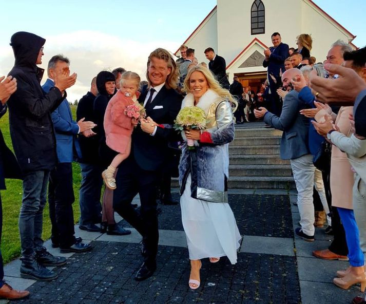 Davíð og Jóhanna Guðrún ganga alsæl niður kirkjutröppurnar ásamt dóttur þeirra eftir athöfnina í Garðakirkju í dag.