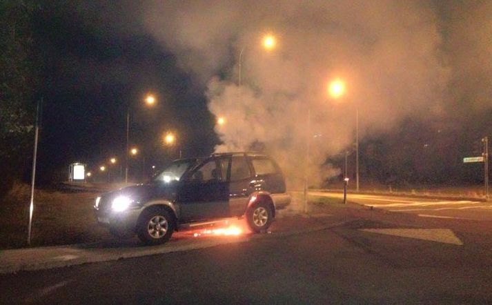 Aron ók bílnum upp á gangstétt og stóðu ljósi  logar undan bílnum.