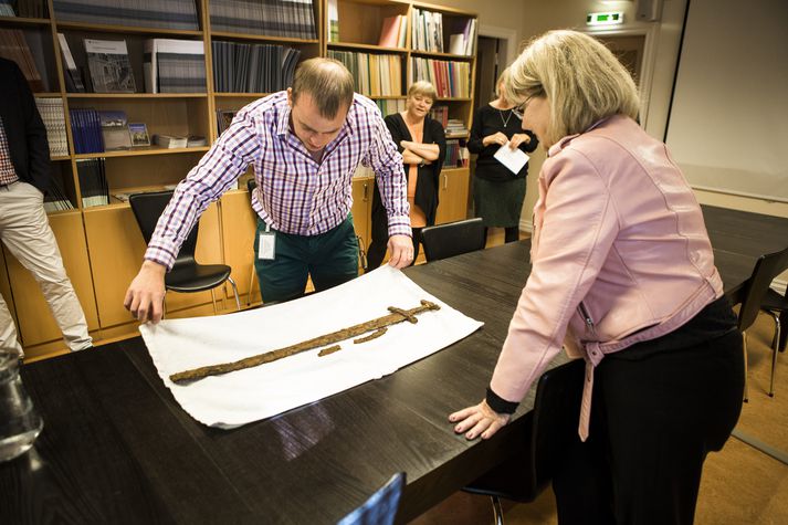 Rúnar Stanley Sighvatsson, einn fundarmanna, og Kristín Huld Sigurðardóttir, forstöðumaður Minjastofnunar, skoða sverðið við afhendinguna.