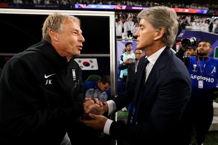 Roberto Mancini, þjálfari Sádi Arabíu, tekur í höndina á Jurgen Klinsmann, þjálfara Suður-Kóreu, fyrir leikinn.