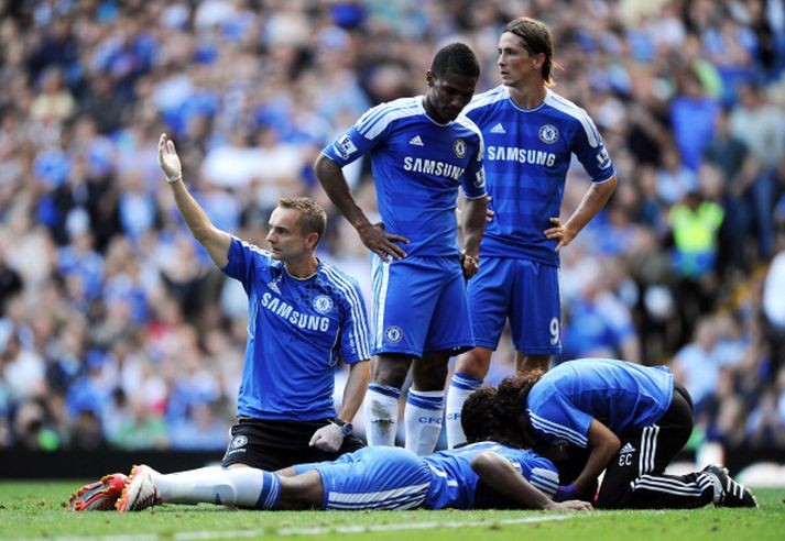 Hugað að Drogba sem gat ekki borið hendurnar fyrir sig þegar hann lenti enda rotaður.