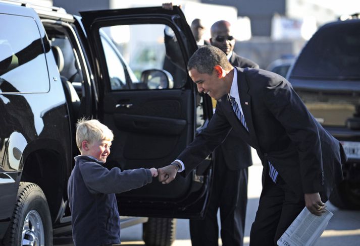 Barack Obama, forseti Bandaríkjanna, klessir barn.