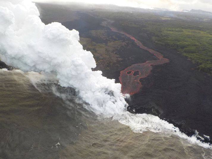 Miklir gufustrókar myndast þegar rauðglóandi hraunið kemst í snertingu við sjóinn.