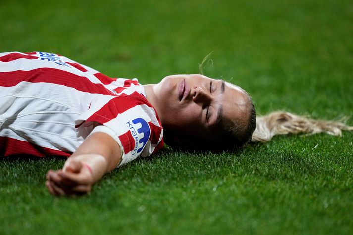 Andrea Medina hjá Atletico Madrid liggur rotuð í grasinu eftir höggið.