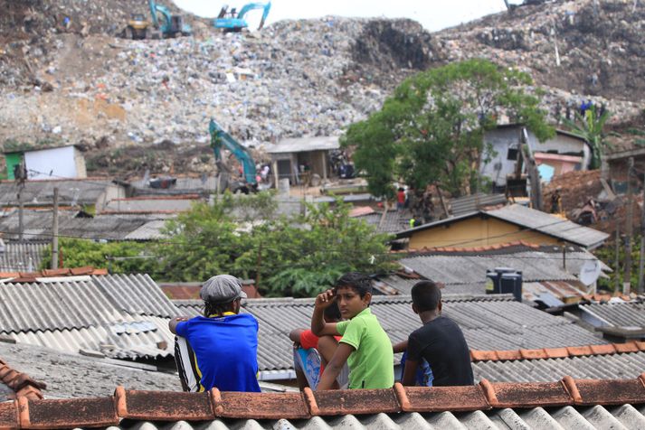 Drengir í Colombo í Sri Lanka virða fyrir sér ruslahauginn sem olli hræðilegri eyðileggingu.