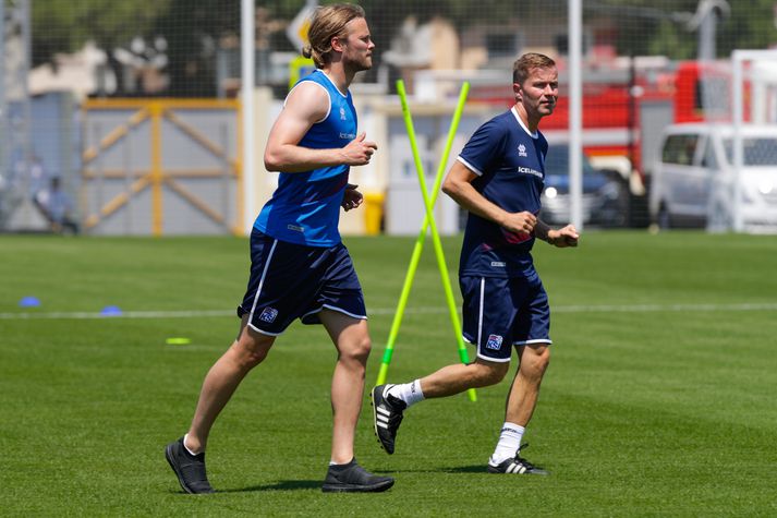 Birkir Bjarnason, í íþróttaskóm, á léttu skokki með Friðriki Ellerti Jónssyni, sjúkraþjálfara liðsins.