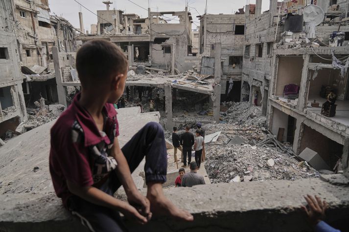 Palestínumenn skoða rústirnar af heimili Al-Lahham fjölskyldunnar, sem eyðilagðist í loftárásum Ísraelshers í Khan Younis á Gazaströndinni á fimmtudag.