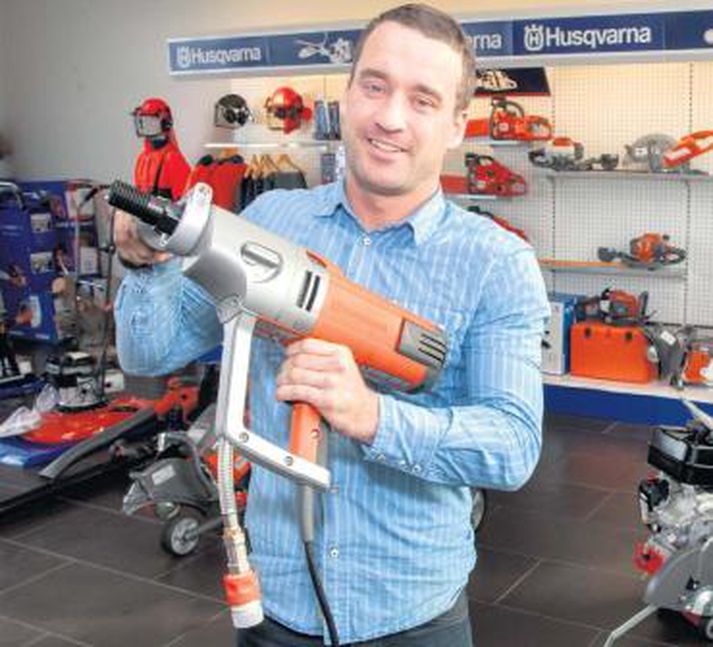 Hilmar Stefánsson, sölu- og markaðsstjóri MHG verslunar, með appelsínugula Husqvarna-kjarnaborvél í fanginu. Hann segir Husqvarna enn framleiða saumavélar, mótorhjól, haglabyssur og margt fleira.