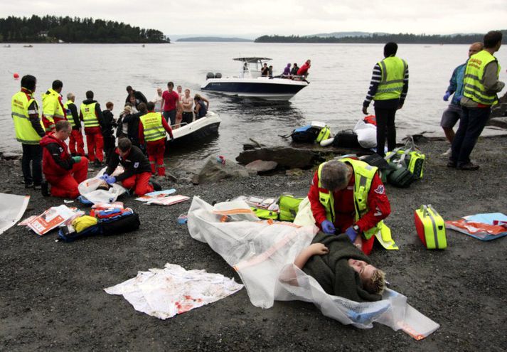 Slösuð kona hlýtur aðhlynningu eftir að hafa verið flutt af Útey á nálæga strönd.