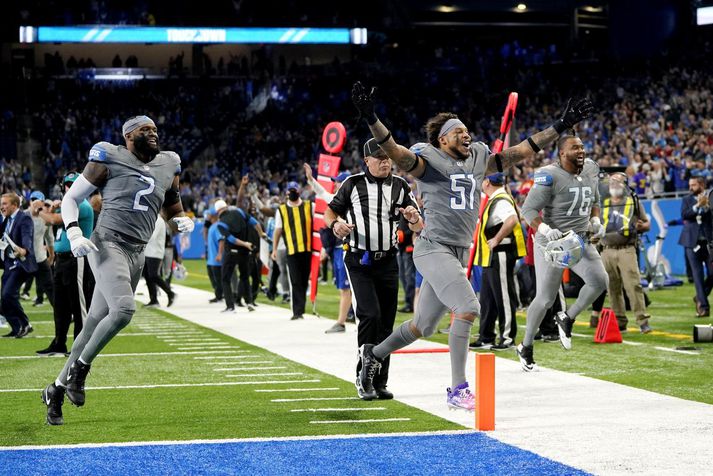 Detroit Lions leikmennirnir Josh Woods (51) og Austin Bryant fagna hér langþráðum sigri liðsins í NFL-deildinni í gær.