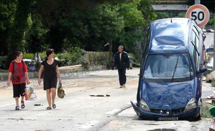 Eftir flóðið. Íbúar virða fyrir sér eyðilegginguna.