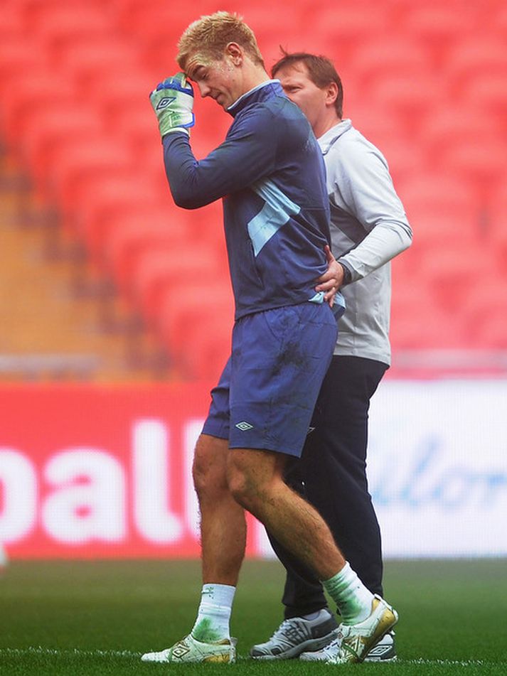 Joe Hart fer hér meiddur af æfingu enska landsliðsins.