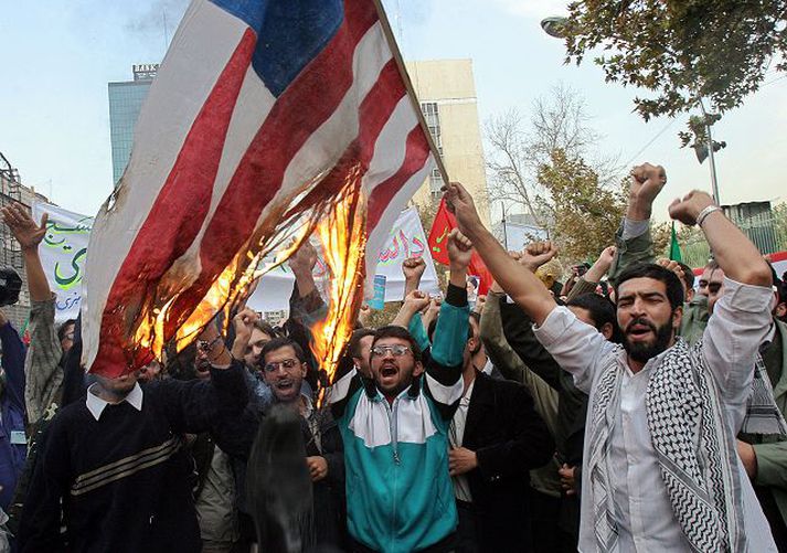 Bandaríkjunum bölvað. Mótmæli voru höfð í frammi fyrir framan bandaríska sendiráðið í Teheran í gær en á morgun eru 26 ár liðin síðan herskáir stúdentar lögðu það undir sig og héldu gíslum í 444 daga.